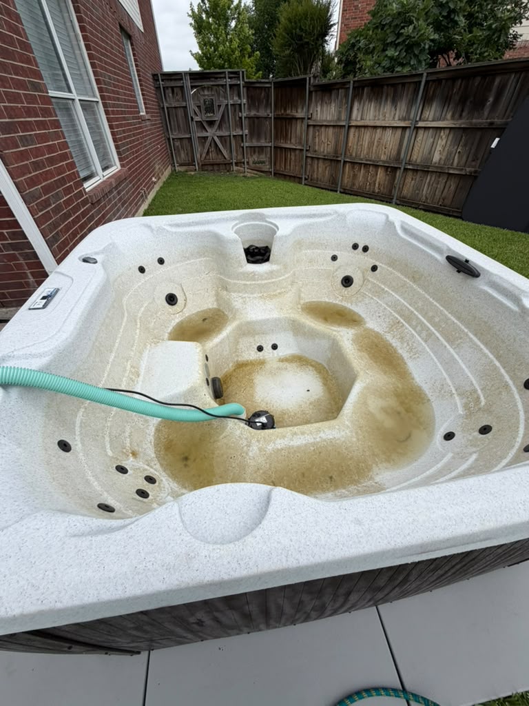 Drained hot tub being deep cleaned